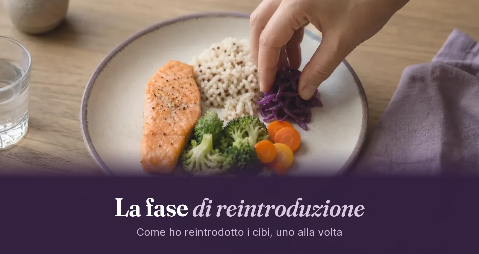 Mano che aggiunge cavolo viola a un piatto con salmone, riso, broccoli e carote